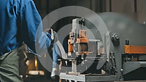 Factory employee using modern cutting lathe for make hole in metalworking detail
