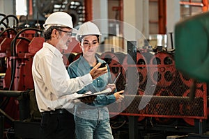 Factory engineer with assistant using laptop inspect factory. Exemplifying