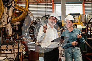 Factory engineer with assistant using laptop inspect factory. Exemplifying