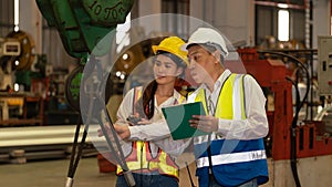 Factory engineer with assistant using laptop inspect factory. Pano Exemplifying