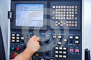 Factory engineer controlling and pressing important technology button at control panel.