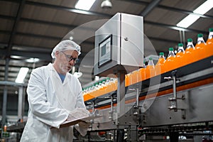 Factory engineer maintaining record on clipboard in factory