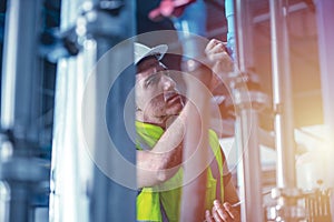 Factory engineer worker repair and checking high pressure water pipe in factory boiler room