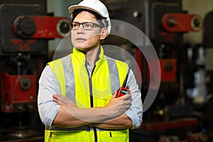 Factory engineering manager asian man Working and holding radio walkie talkie at Metal lathe industrial manufacturing factory.