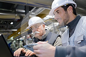 Factory engineers looking at laptop