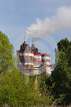 Factory with industrial smoke stacks on nature