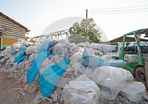 Factory industry with stack of different types of large garbage dump, plastic bags, bottles and trash bins in urban area in