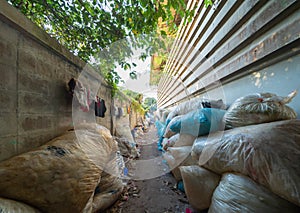 Factory industry with stack of different types of large garbage dump, plastic bags, bottles and trash bins in urban area in