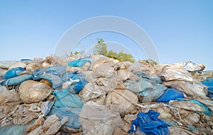 Factory industry with stack of different types of large garbage dump, plastic bags, bottles and trash bins in urban area in