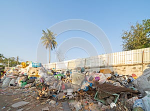 Factory industry with stack of different types of large garbage dump, plastic bags, bottles and trash bins in urban area in