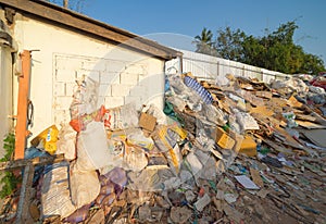 Factory industry with stack of different types of large garbage dump, plastic bags, bottles and trash bins in urban area in