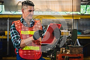 Factory inspector foreman holding clipboard checking job list in factory