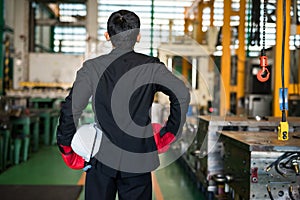 Factory manager with boxing gloves ready to fight