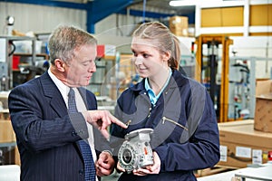 Factory Manager And Engineering Apprentice Discussing Component