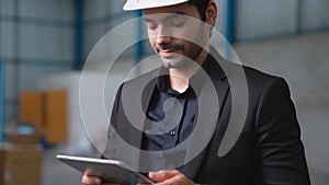 Factory manager using tablet computer in warehouse or factory