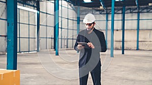 Factory manager using tablet computer in warehouse or factory