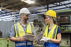 Factory manager and worker. Young man and Young woman are discussing in industrial plants. Engineer with clipboard and tablet on