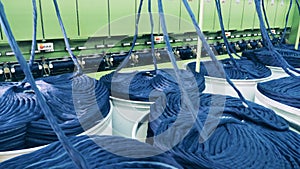 Factory mechanism is slowly unwinding strands of cloth