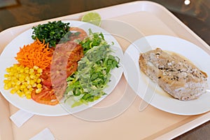 Salad of lettuce, tomato, corn, carrot and chicken steak