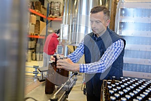 Factory operative packing bottles from end production line