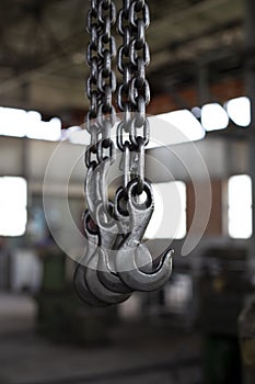 Factory overhead crane. Black steel chain and hooks