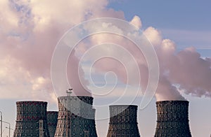 Factory pipes or Cooling towers of nuclear power plant with steam. Environmental