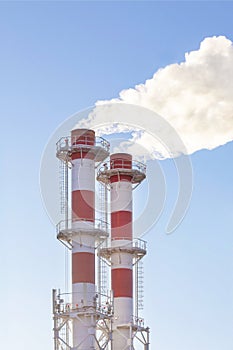 Factory plant smoke stack over blue sky background. Thermal condensing power plant.