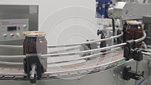 Factory production line with glass jars moving over conveer