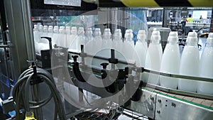 Factory and research concept. Clip. Bottles with white substance standing on manufacturing facility going to be twisted