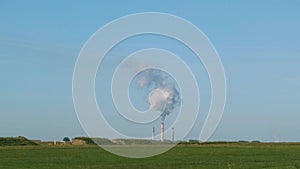 Factory with smoking chimneys in summer day