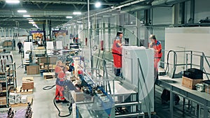 Factory staff are manually fabricating fridges