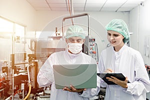 Factory staff worker check quality control in factory or industry research team collect data in beverage factory with laptop