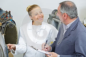 Factory supervisor giving instructions to female apprentice