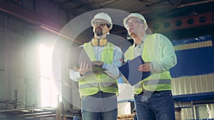 Factory unit with two male inspectors having a discussion in it