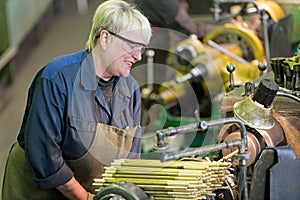 Factory woman turner working on workshop lathe machine