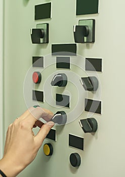 Factory worker adjusts the control panel of industry machine