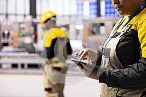 Factory worker analyzing data on tablet