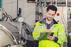 Factory worker Arab Hispanic engineer working in factory checking maintenance pipe boiler system in factory