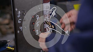 Factory worker assembling electric equipment - transformer - on assembly Line. High voltage components Manufacturing.