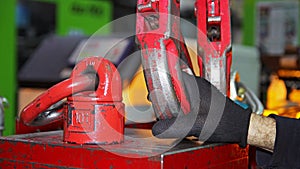 Factory Worker Attaching Crane Hooks to a Heavy Load