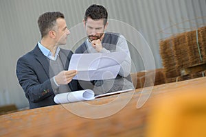 Factory worker and boss checking paper