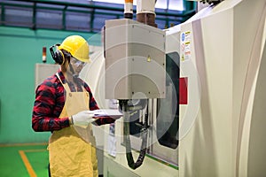 Factory worker check manual paper to command CNC panel