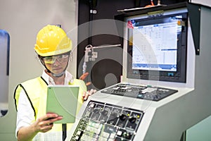 Factory worker check stock near machine monitor