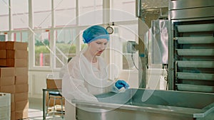 Factory worker checking packing machine. Candy factory.