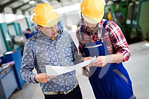 Factory worker discussing data with supervisor in metal factory