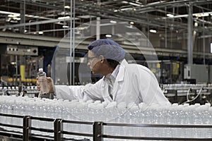 Factory worker examining bottled water