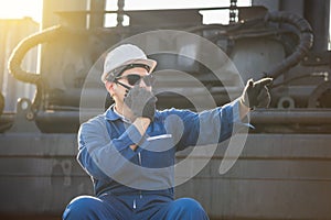 Factory worker in hard hat talks on two-way radio control loading containers box from cargo