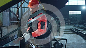 Factory worker at industrial zone moving some heavy machinery and start to work he wearing safety helmet and equipment