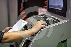 Factory worker on keyboard to command machine