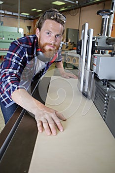 Factory worker operates laser cutting machine in workshop